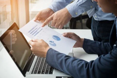 Teamwork process, Businessmen hands pointing at laptop and document during ex Stock Photos