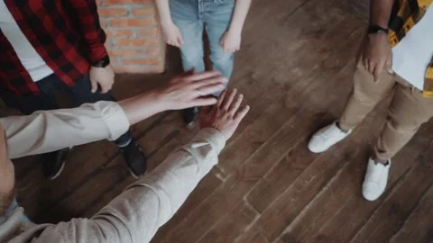 Teamwork success, office workers fold their hands celebrating the launch of a Stock Footage 131673549