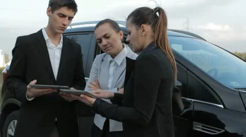 Teamwork with tablets next to car Stock Footage 12374672