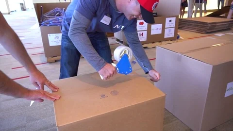 Teamwork Taping A Cardboard Packing Box Video stock 82812941