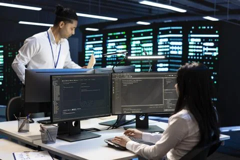 Teamwork, technicians and troubleshooting at data center workstation Stockfoto's