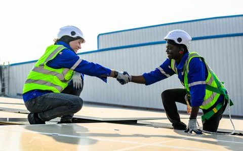 Teamwork technicians workers installing solar panels at solar cell farm Stock Photos