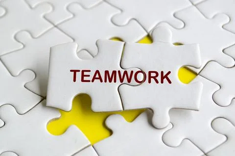 Teamwork text on missing jigsaw puzzle. Unity and One Team concept Stock Photos