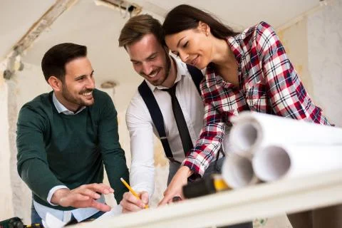 Teamwork. Three young architects working on a project Stock Photos
