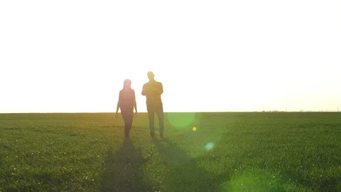 Teamwork. Two farmers a man and a woman work on the field in the evening before Video stock 121529563