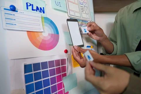 Teamwork in UI Design. Hands placing elements on a planning board. Foto stock
