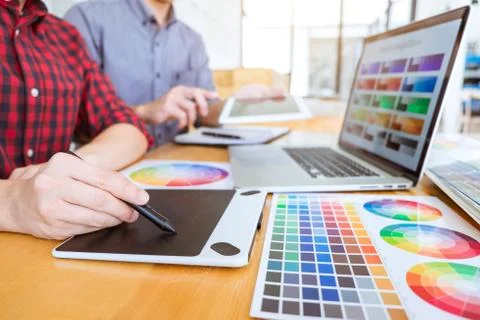 Teamwork of young creative designers working on project together and choose c Stock Photos