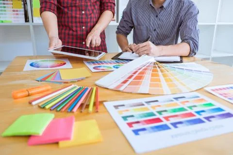 Teamwork of young creative designers working on project together and choose c Stock Photos