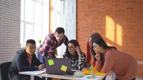 Teamwork. young guys in the office are standing by the computer and discussing Stock Footage 86795039