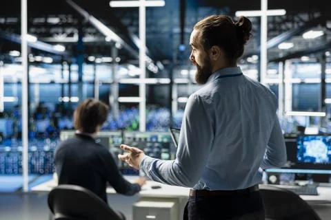 Teamworking admins coding in data center, updating AI driven automation scripts Foto stock