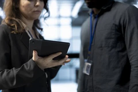 Teamworking colleagues in data center using tablet, analyzing metrics Stock Photos