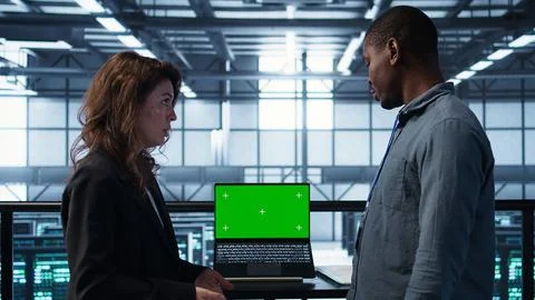 Teamworking IT experts adjusting server room configurations with mockup laptop Stock Photos