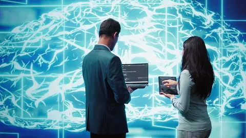 Teamworking IT staff members using AI system aiding in processing Stock Footage 278699775