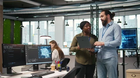 Teamworking programmers in office reviewing AI system metrics Stock Footage 313168121