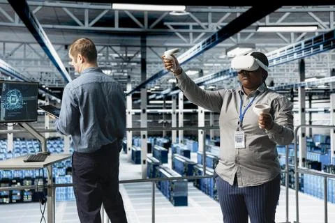 Teamworking server farm programmers using VR headset, running AI simulations Stock Photos