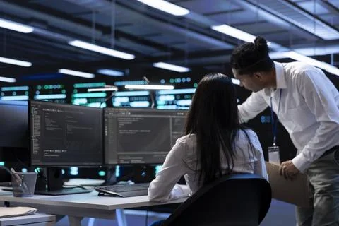 Teamworking technicians in server room looking to find network issues Stock Photos