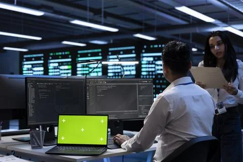 Teamworking technicians in server room using green screen laptop Foto stock