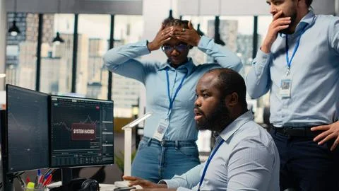 Teamworking traders in office work together to resolve hacker security alert Stock Photos