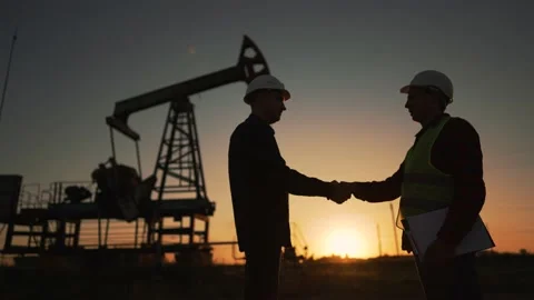 Teamwork.Oil engineer in helmet work with an oil pump.Silhouette of worker in 動画素材 222980938