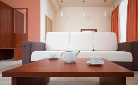 Teapot and cups on the background of the sofa Фото