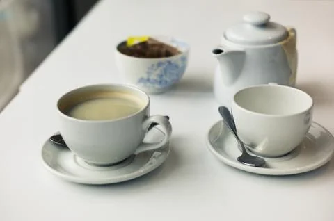 Teapot and cups on table Foto stock