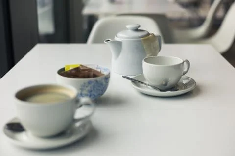 Teapot and cups on table Photos