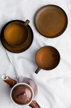Teapot and empty brown tea cups Stock Photos