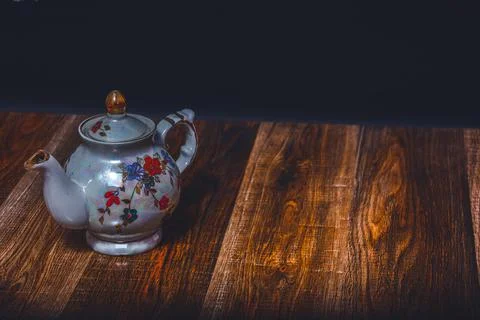 A teapot on the background of an ancient torn texture. Action. Beautiful shin Foto stock