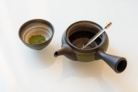 Teapot with a cup of green tea Stock Photos