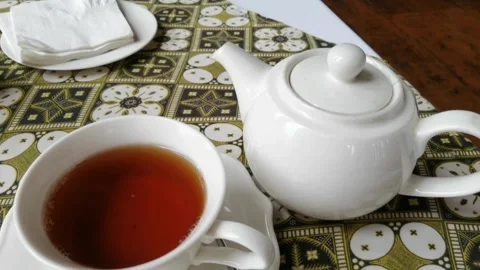 A teapot with a cup of vanilla tea Stock Footage 260538638
