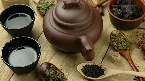 Teapot with different types of tea and accessories stands on wooden table Stock Footage 127363110