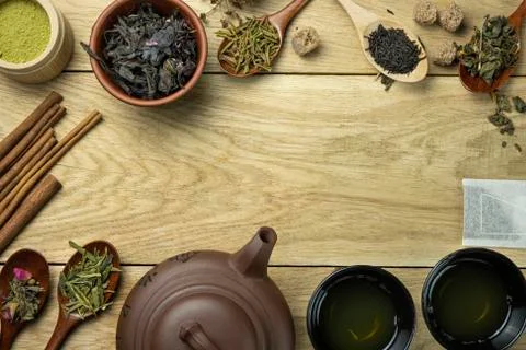 Teapot with different types of tea and accessories stands on wooden table Stock Photos