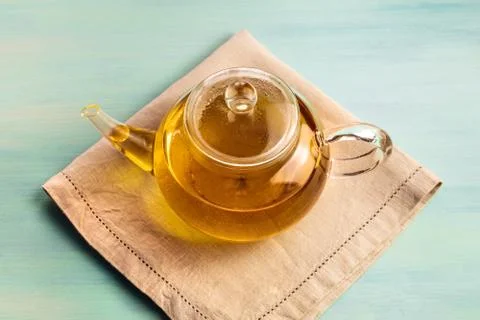 Teapot full of tea on teal texture with copyspace Stock Photos
