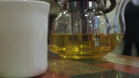 Teapot with green tea with a cup on the table in the cafe Stock Footage 147206145