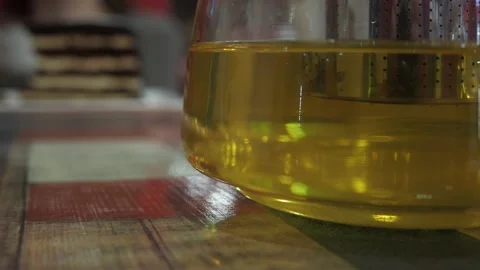 A teapot of green tea with a cup on the table. the camera passes from left to Stock Footage 147339888