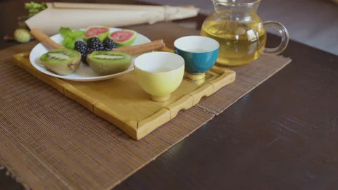 Teapot with green tea, two cups and fruits Stock Footage 97792804