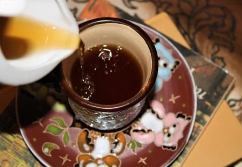 From the teapot pour tea into a Cup Stock Photos