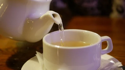 Teapot pouring tea in cup Video stock 105785301