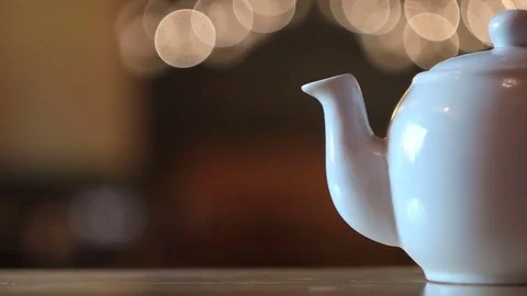 Teapot on a table in the background of bright lights Stock Footage 77574513