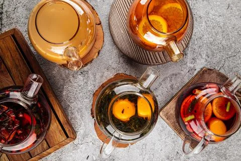 Teapots with various tea on the gray table Stock Photos