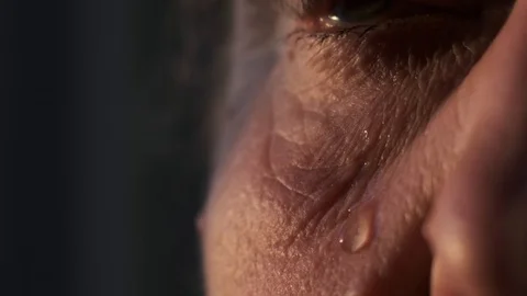 A tear flows down the cheek of an old woman, close-up 库存影片 115050188