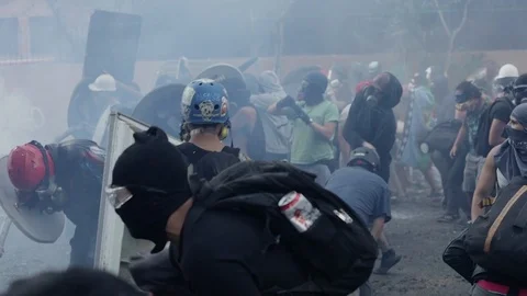 Tear gas clouds around protestors at a civil protest in Santiago, Chile Video stock 124219577
