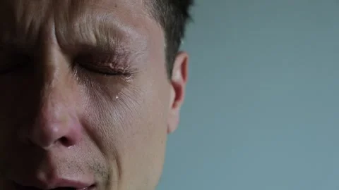 Tear rolling down a mans cheek. Close up of Crying man with tears in eye Stock-Footage 311871260