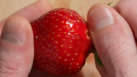Tear off the stem from the strawberry. Close-up Slow motion 動画素材 244526584