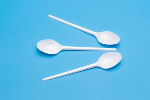 Teaspoon and plastic fork and glass tumbler Stock Photos