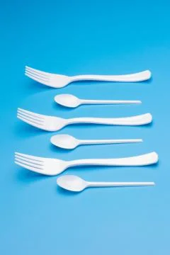 Teaspoon and plastic fork and glass tumbler Stock Photos