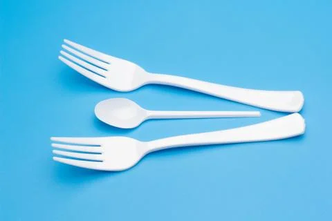 Teaspoon and plastic fork and glass tumbler Stock Photos