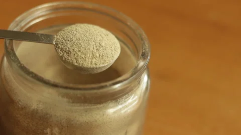 A teaspoon of finely white ground pepper powder is being scooped with stainless Stock Footage 222686058