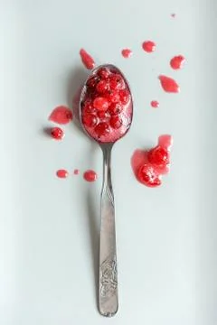 Teaspoon with fresh red currant jam and splashes Stock Photos