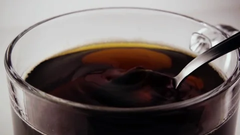 A teaspoon scoops the tea in a cup. Slow motion Stock Footage 75676814